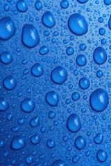 Poster - Close-up of vibrant blue water droplets on a smooth surface, creating a refreshing and cool texture.