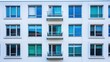 © yoga - Modern building facade featuring windows and balconies in a symmetrical arrangement.