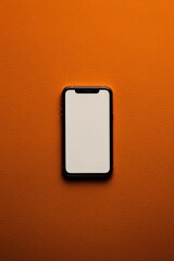 Aufkleber - A smartphone with a slim metallic profile set on a soft suede surface, with its interface glowing in warm tones