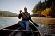 © Cavan Images - Man Seriously Paddles Canoe In Early Morning Light