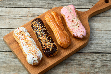 Wall Mural - Assorted eclairs on a pastel top view Traditional French dessert