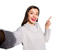 © deagreez - Photo of pretty lady making selfies indicating arm empty space wear warm knitted pullover isolated blue background
