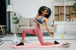 © Nuttapong punna - A young woman practices yoga and stretching with a mat and gym props, showcasing wellness, motivation,