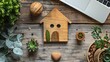 © Arifin Studio - Wooden house figure with plants and laptop on wood.