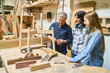 © Robert Kneschke - Mentor guiding apprentices in a woodworking workshop