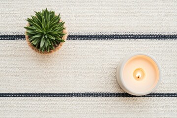 Aufkleber - Burning candle and green plant creating relaxing atmosphere on cozy striped rug