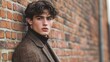 © Christopher - Young male model posing against a large brick wall with a relaxed expression
