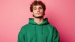 © Ludmila Zabaranilova - Photo of nice young man calm serious face wear green hoodie isolared on pink color background