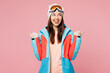© ViDi Studio - Skier young happy woman wear warm blue padded jacket ski goggles mask spend extreme weekend winter season in mountains point thumb finger aside on area isolated on plain pink background Hobby concept