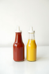 Poster - Empty bottles of ketchup and mustard sit on a clean, white surface with labels still intact._00004_