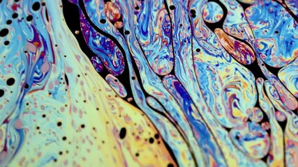 Wall Mural - Closeup video of a soap bubble showing thin film interference concept and the resulting different colors of light with each moving and swirling shapes. Perfect for illustrating concepts of physics.