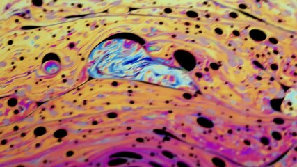 Wall Mural - Closeup video of a soap bubble showing thin film interference concept and the resulting different colors of light with each moving and swirling shapes. Perfect for illustrating concepts of physics.
