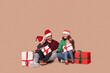 © Pixel-Shot - Happy family in Santa hats with Christmas gifts on beige background
