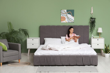 Wall Mural - Morning of pretty young woman reading book in bed