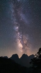 Poster - Serene view of the Milky Way galaxy illuminating a night sky over rugged mountain silhouettes
