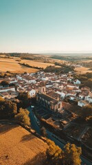 Poster - Breathtaking aerial view of a historic town surrounded by lush fields and rolling hills at sunset
