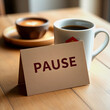 © PrismaVibe Studio  - Message with the sing of pause card on paper and cup of coffee on a table