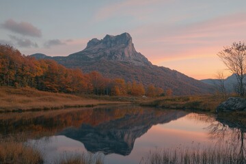 Poster - Serene mountain landscape at sunset with vibrant autumn foliage and calm reflection in water.