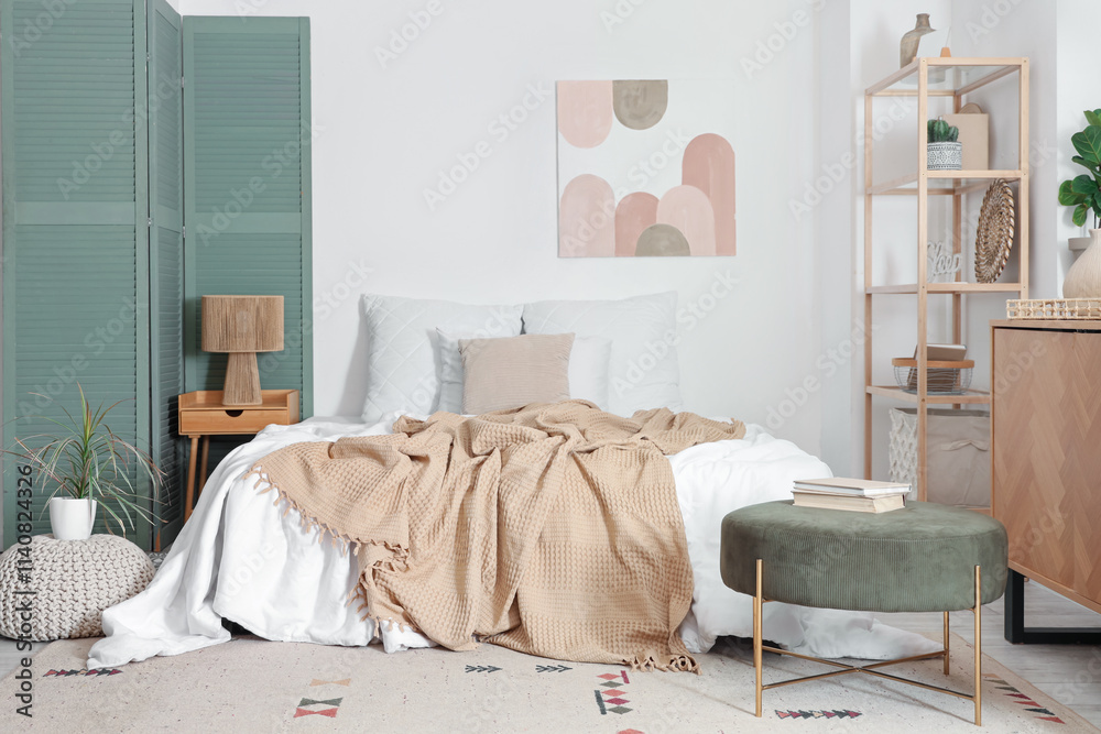 Interior of light bedroom with shelf unit and painting