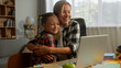© Yuliia - Happy Caucasian parent mother speak teach glad daughter little child kid how to use laptop woman help homework online at home family success female clap hands pupil girl high five schoolgirl hug mom
