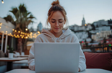 Wall Mural - Woman Using Laptop on Balcony at Sunset