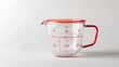 © Adnan - A transparent measuring cup with red markings isolated on a white background