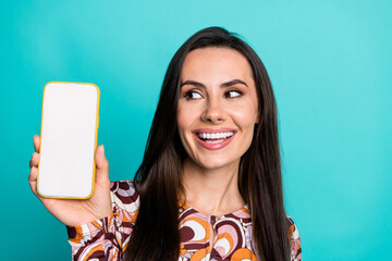 Wall Mural - Photo of charming positive woman wear print shirt looking modern device empty space isolated teal color background