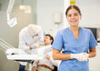 © JackF - Young woman nurse in blue suit uniform is standing in dental office, clinic employee in suit uniform near dentists workplace. Doctor enjoys working in profession.