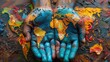 © alva studio - Painted hands cradling a colorful world map.