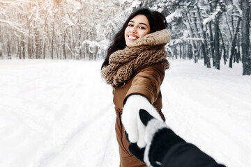 Wall Mural - Follow Me. Smiling Girl Holding Boyfriend's Hand Pulling Him To Winter Forest. Panorama, Empty Space