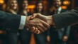 © DARIKA - Closeup of a successful handshake between a businessman and businesswoman, with colleagues in the background, representing professional success and a positive business partnership.