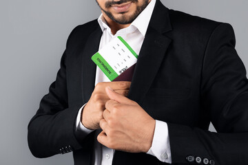 Poster - Cropped of entrepreneur in formal attire is placing a business card into his suit pocket. The environment is a studio, emphasizing his professional lifestyle as a millennial manager.