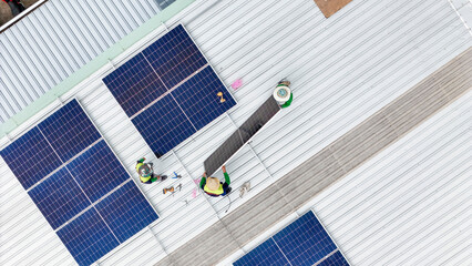 Wall Mural - a team of technicians inspects solar panels on metal rooftop, equipped with tools, laptops, and safe
