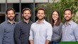 © Jiraphat - A group of five smiling individuals poses together in a modern setting, with greenery in the background and a professional atmosphere.