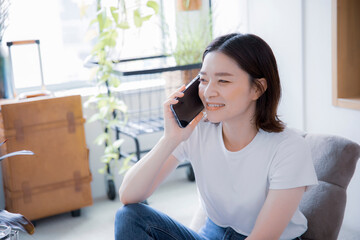 Poster - 明るい室内でスマートフォンで笑顔で通話する日本人女性