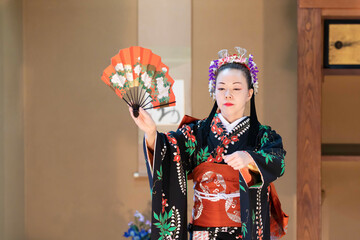 Wall Mural - 着物姿で扇子を持って日本舞踊を踊る若い日本人女性