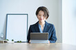 © TAGSTOCK2 - タブレットPCの前に座るスーツ姿の女性