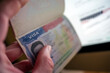 © Bokicbo - Unknown caucasian person holding passport with visa issued for United States of America