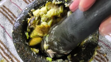 Sticker - Pounding chopped eggplant in mortar, in door  Chiangmai  Thailand.