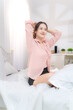 © Wosunan - Asian young woman relaxing before bedtime on the bed in the bedroom