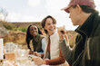 © Maskot - Happy woman talking with male friend at outdoor dinner party during social gathering