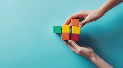 Poster - Hands build colorful blocks on blue background.