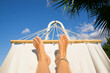 © RooM The Agency - Close-up personal perspective low angle view of a barefoot woman's feet on a hammock in summer