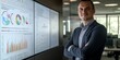 © Christopher - Portrait of a male business analyst standing in an office with charts and data