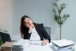 © Tj - Young Asian businesswoman is feeling bored and tired while working with a laptop and many documents on desk at office, feeling no motivation and lazy, burnout and sleepy