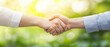 © praewpailyn - warm handshake between two individuals symbolizes trust and collaboration in natural setting. soft focus background enhances positive emotional connection
