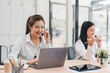 © PRIME STOCK LAB - Two women working in modern office with headsets and laptops