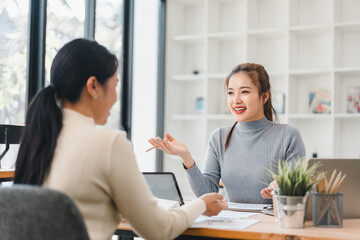 Wall Mural - Two women discussing work at modern office desk