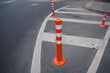 © Tricky Shark - Urban road infrastructure with safety cones and clear street markings, cones in front of the entrance and exit to the building prohibiting parking for cars ensuring traffic safety in cityscape setting