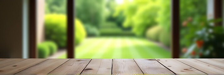 Poster - A worn wooden table sits in front of a blurred garden view with vibrant green foliage seen through the window._00002_